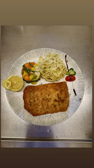 Paniertes Gericht mit Pasta und Zitrone